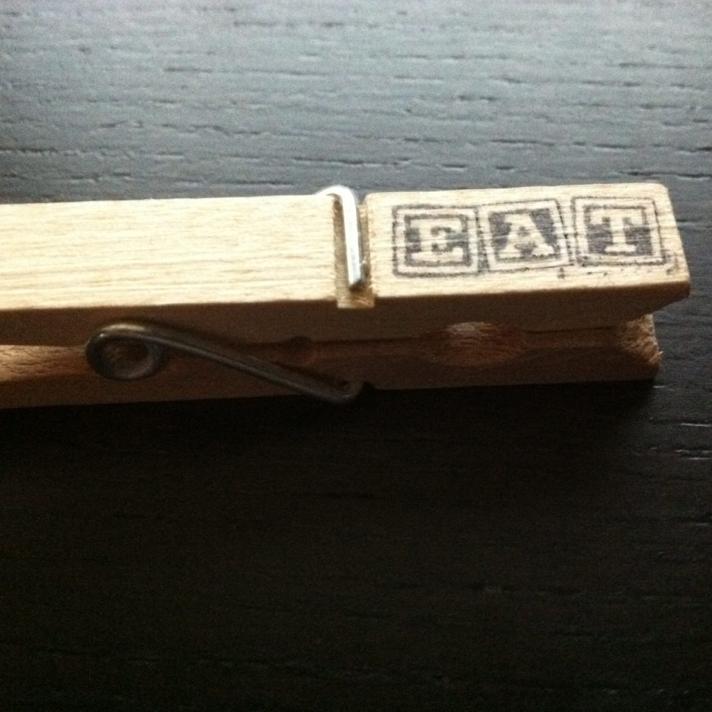 a clothes pin stamped, eat.