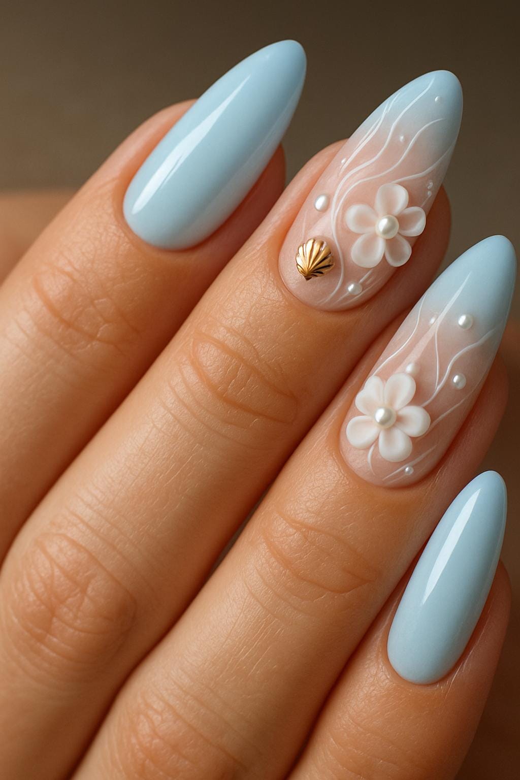 up close woman nails with almond shape soft pastel blue and sheer pink base elegant gold seashell charms on accent nails delicate white 3D flowers