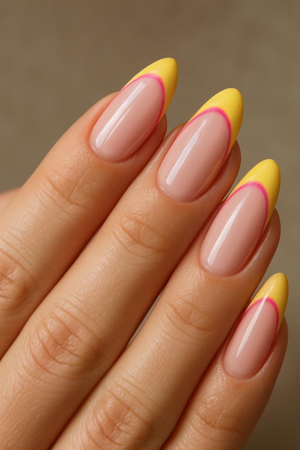 Yellow tips with pink outline on almond-shaped nails