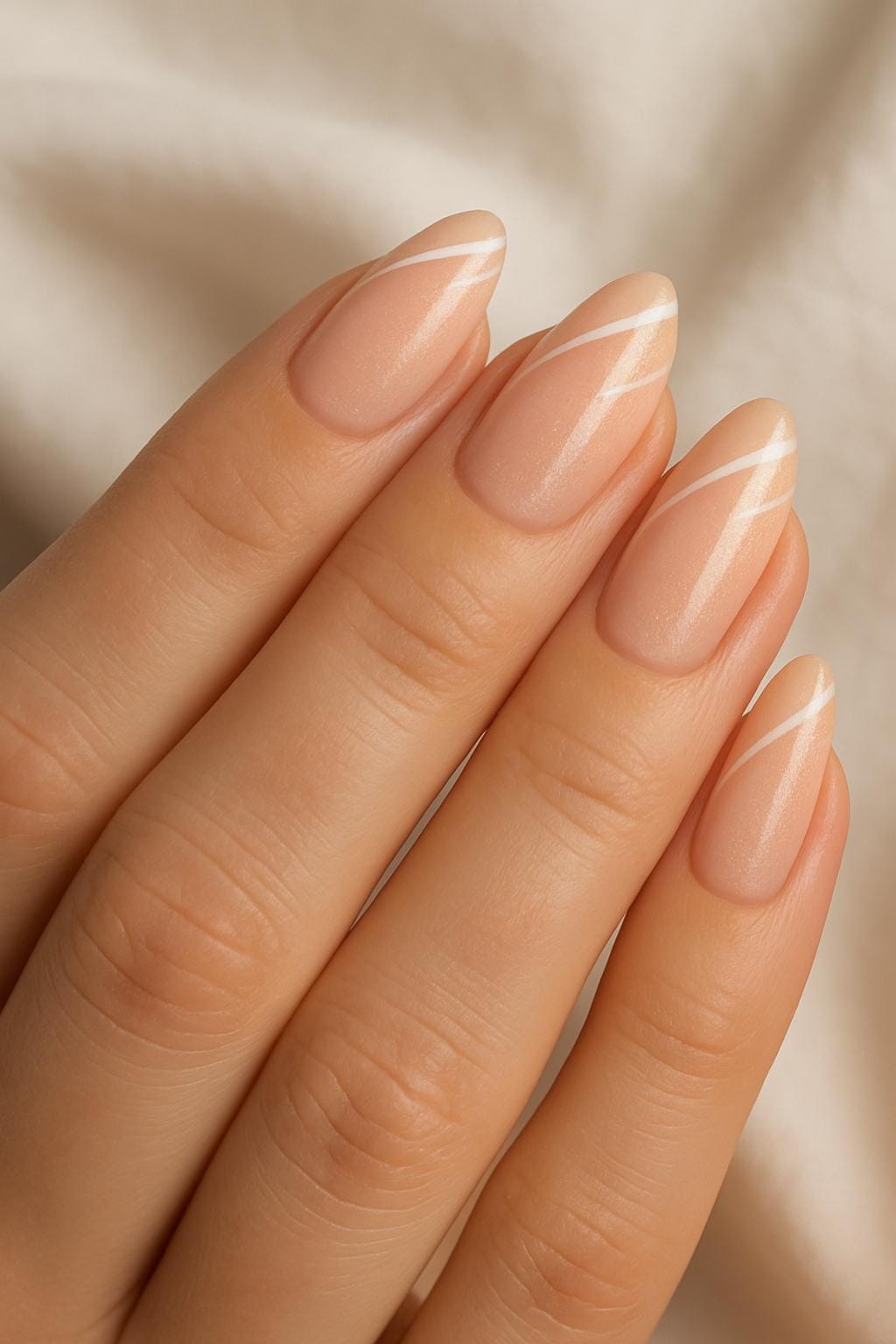 Almond-shaped nude nails with diagonal white minimalist lines