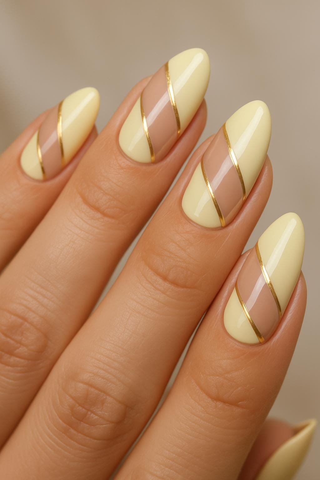 Butter yellow nails with nude negative space and gold stripe accents