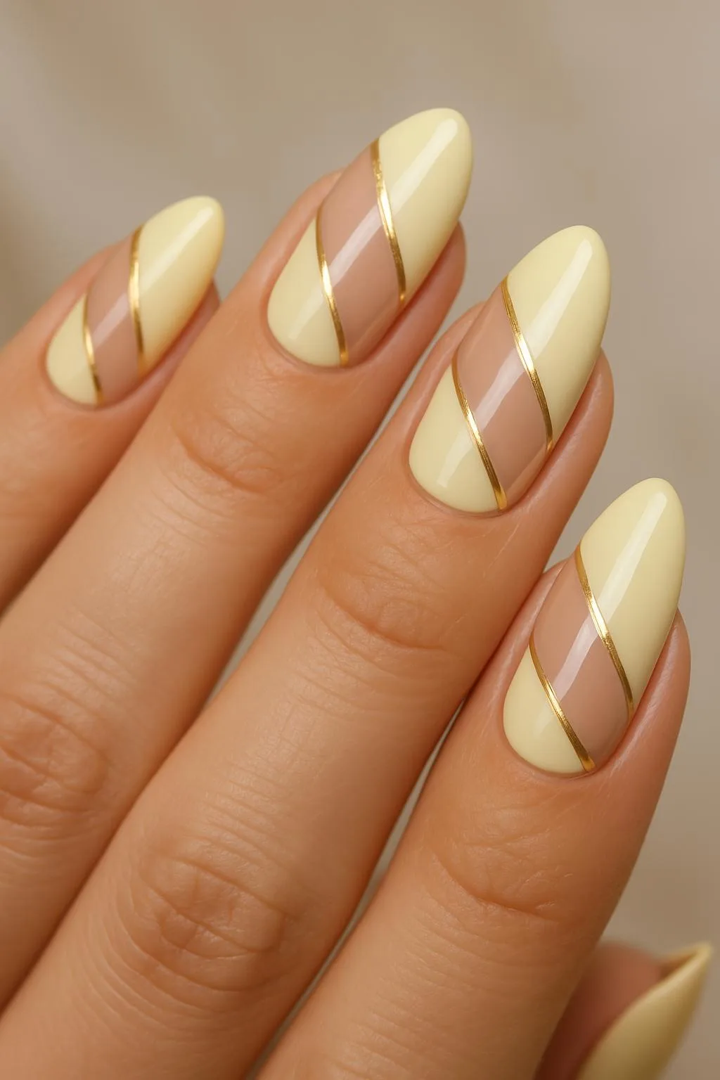 Butter yellow nails with nude negative space and gold stripe accents