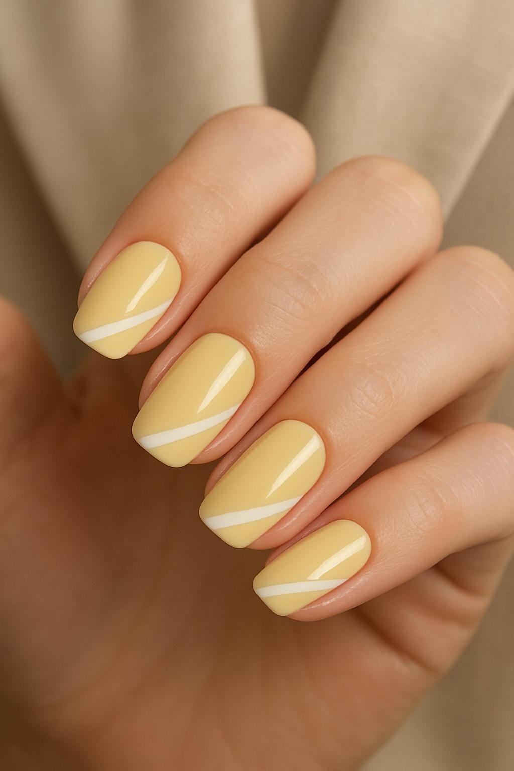 Buttery yellow nails with straight white diagonal stripes