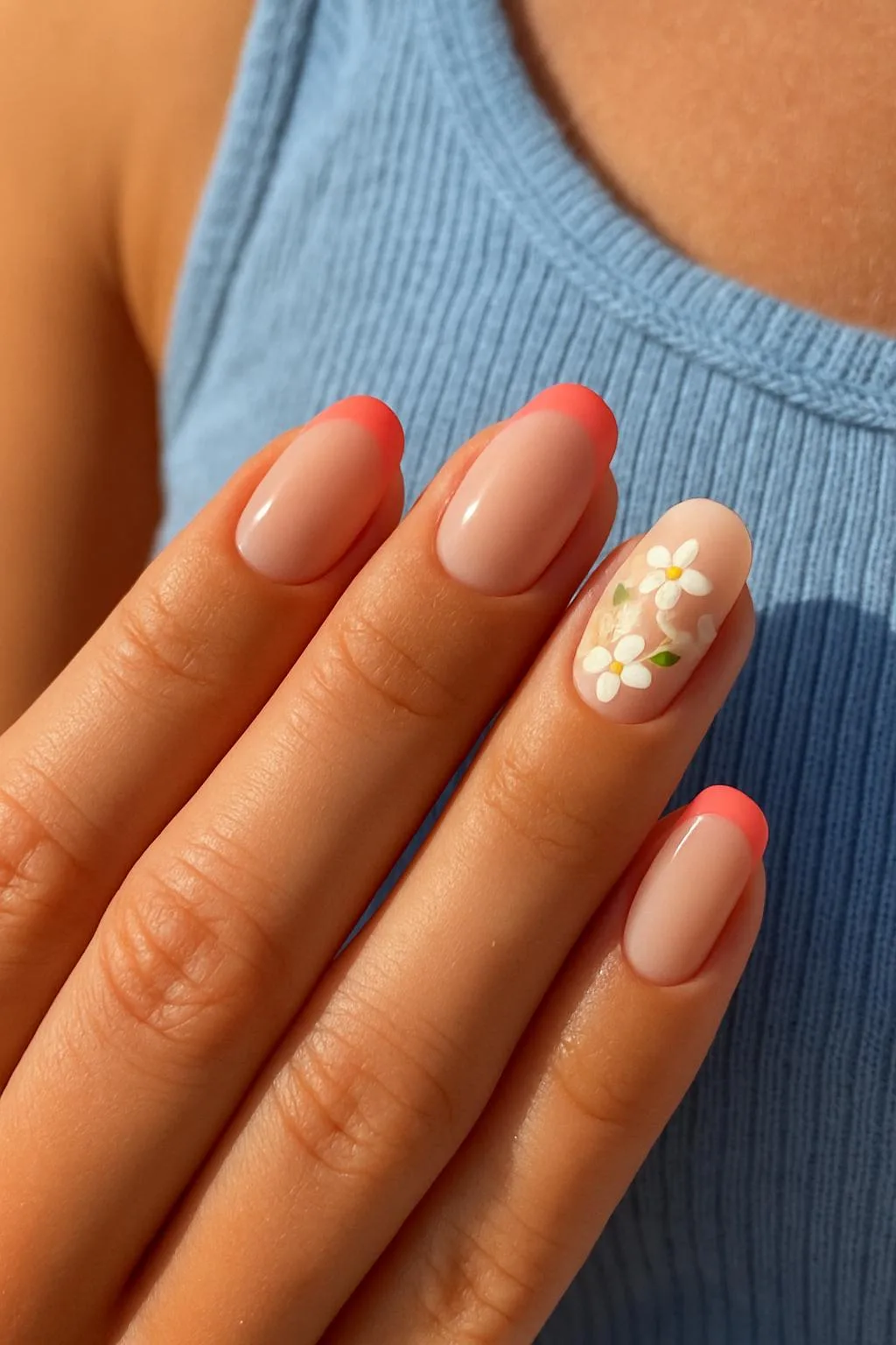 Pink French tips and white floral accent on nude nails