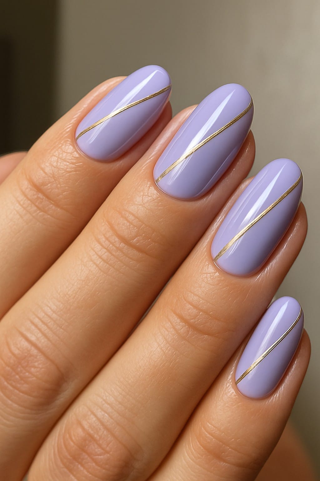 Lilac nails with a gold diagonal stripe accent