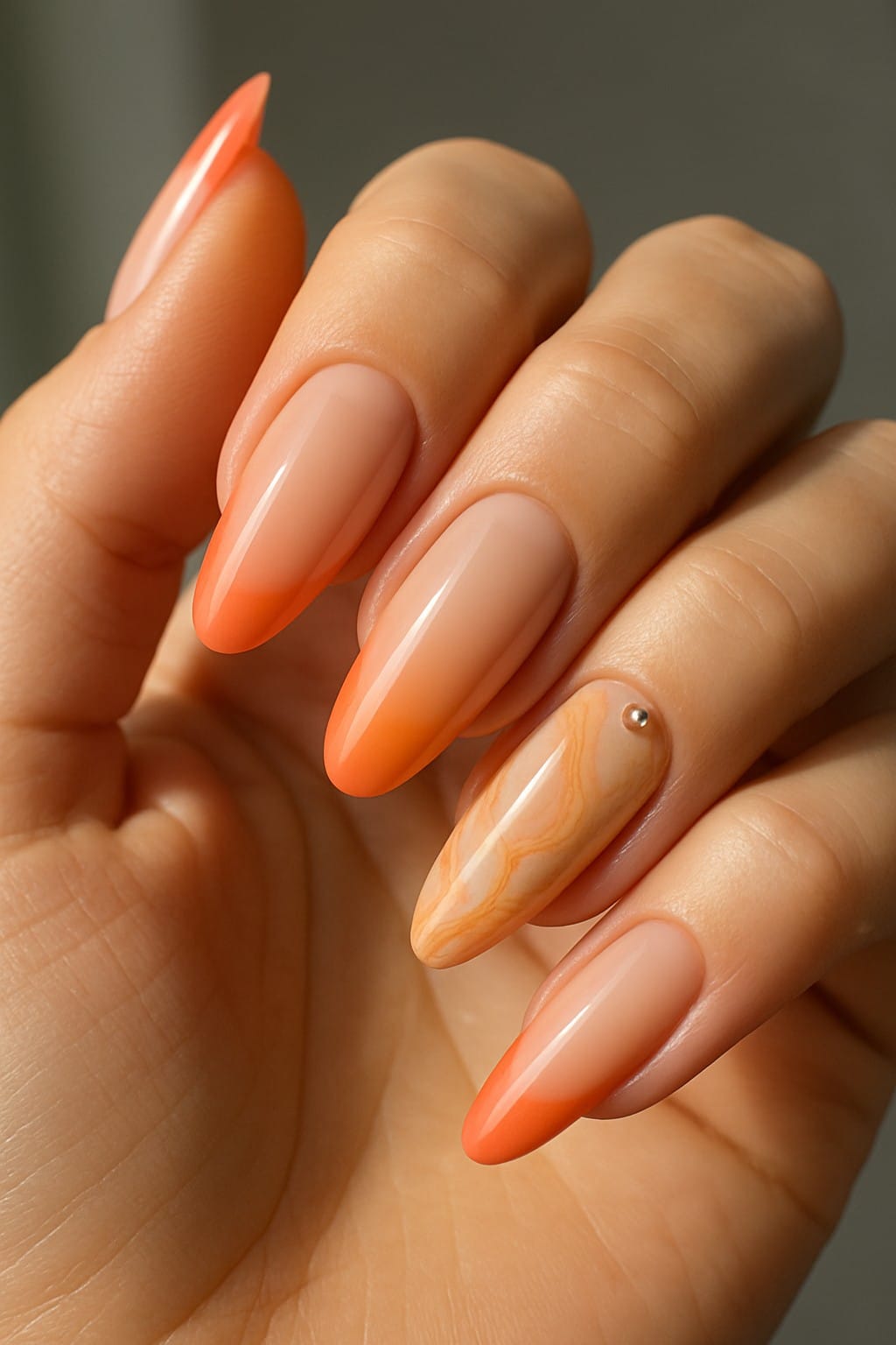 Long almond nails with apricot tips and a marbled accent