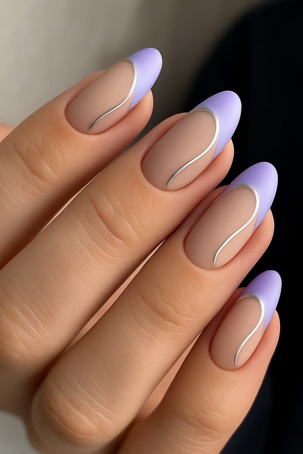 Matte nude nails with pastel purple tips and a silver wavy accent line