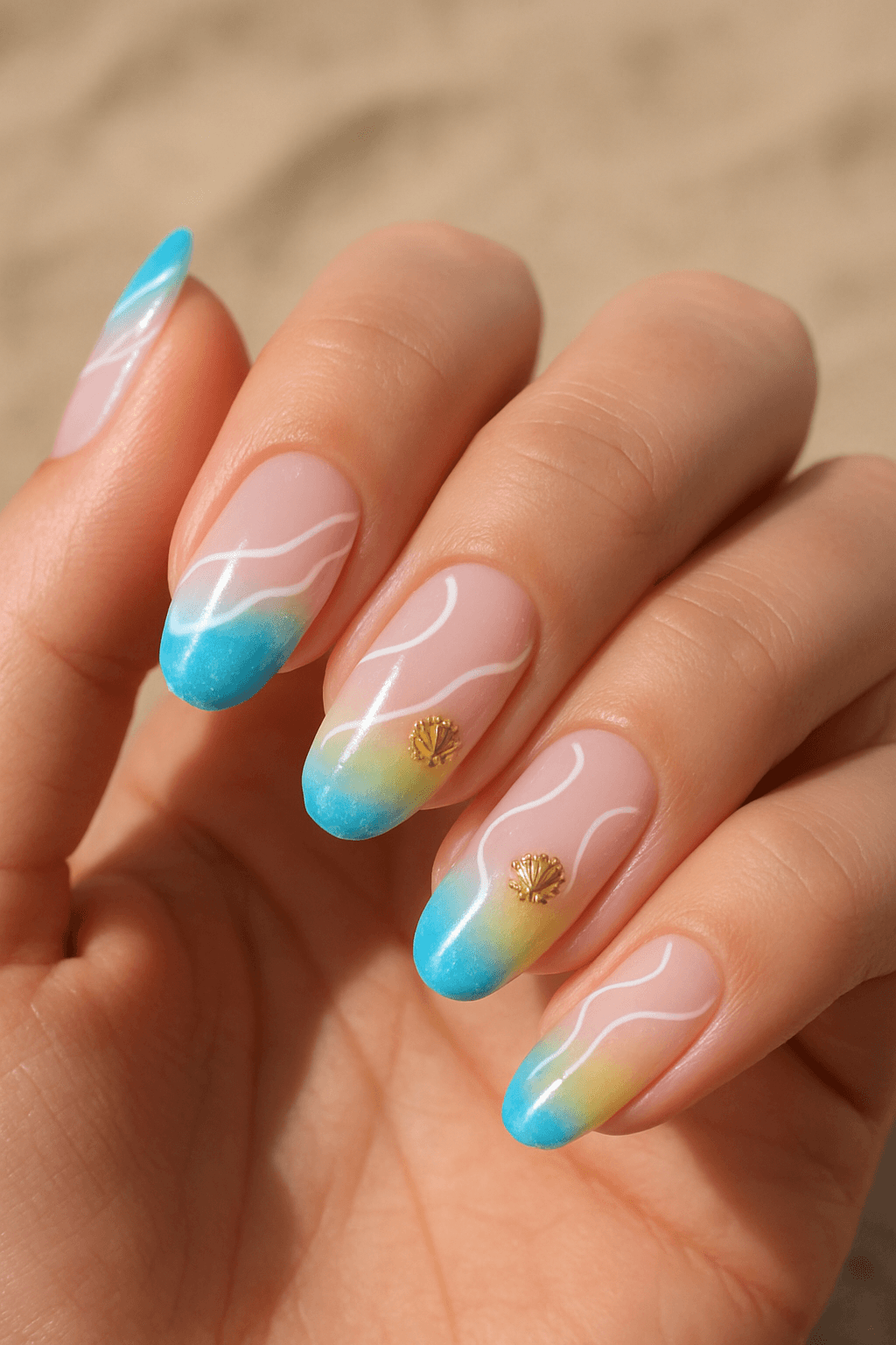 Turquoise ombre nails with white wave designs and gold shell charms