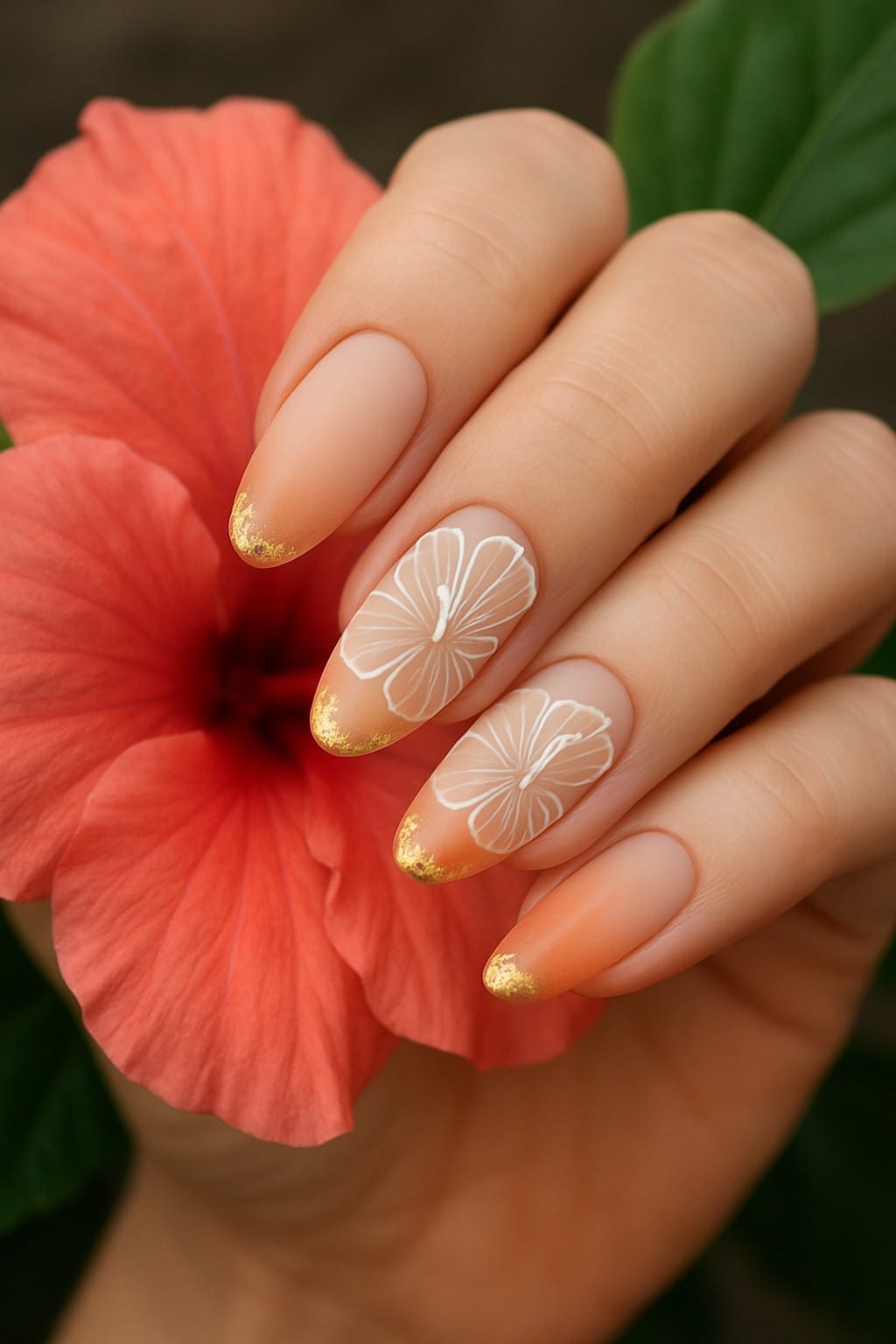 Nude nails with white hibiscus flowers and gold-tipped edges
