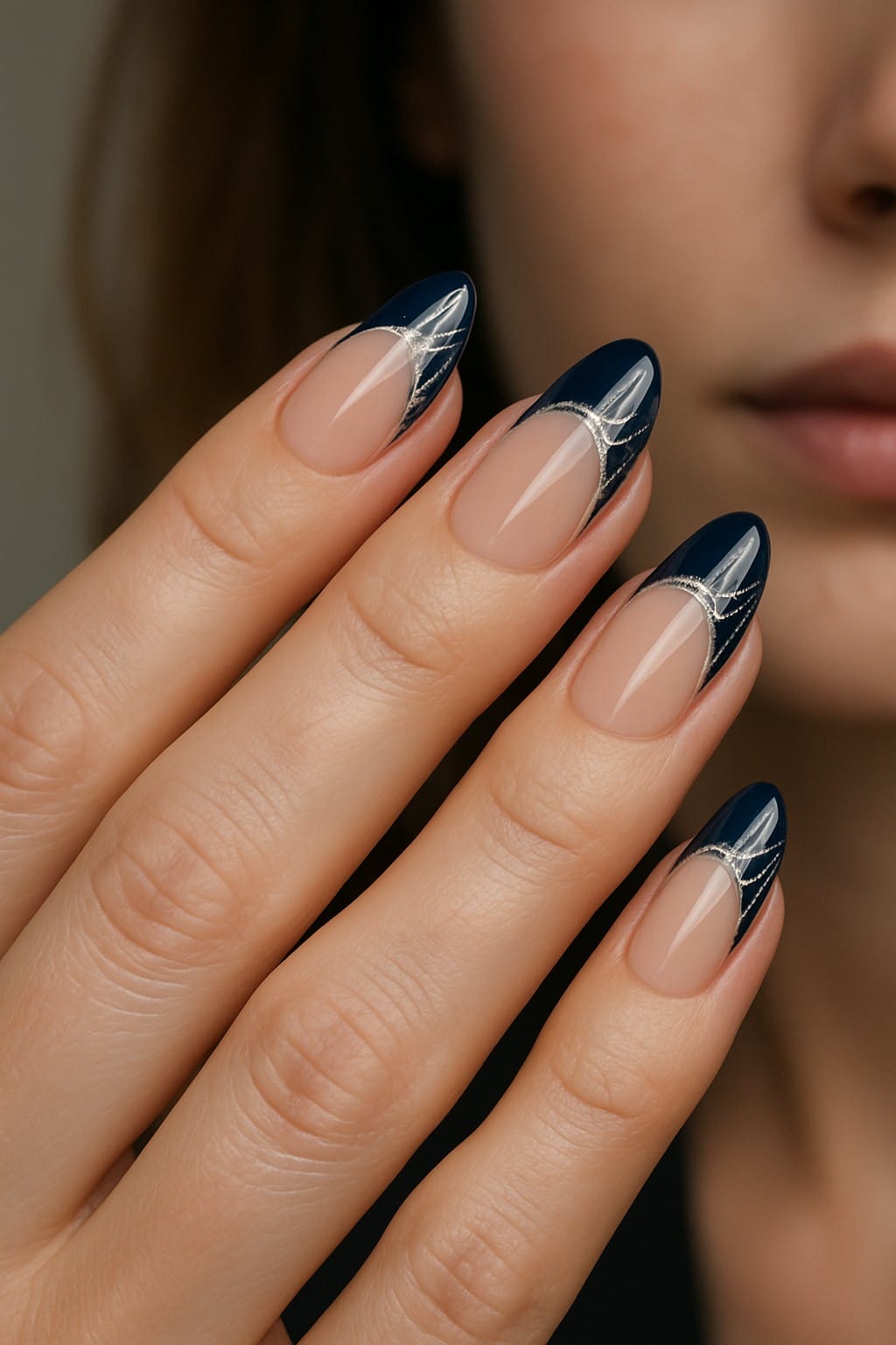 Almond nails with navy blue French tips and silver curved lines
