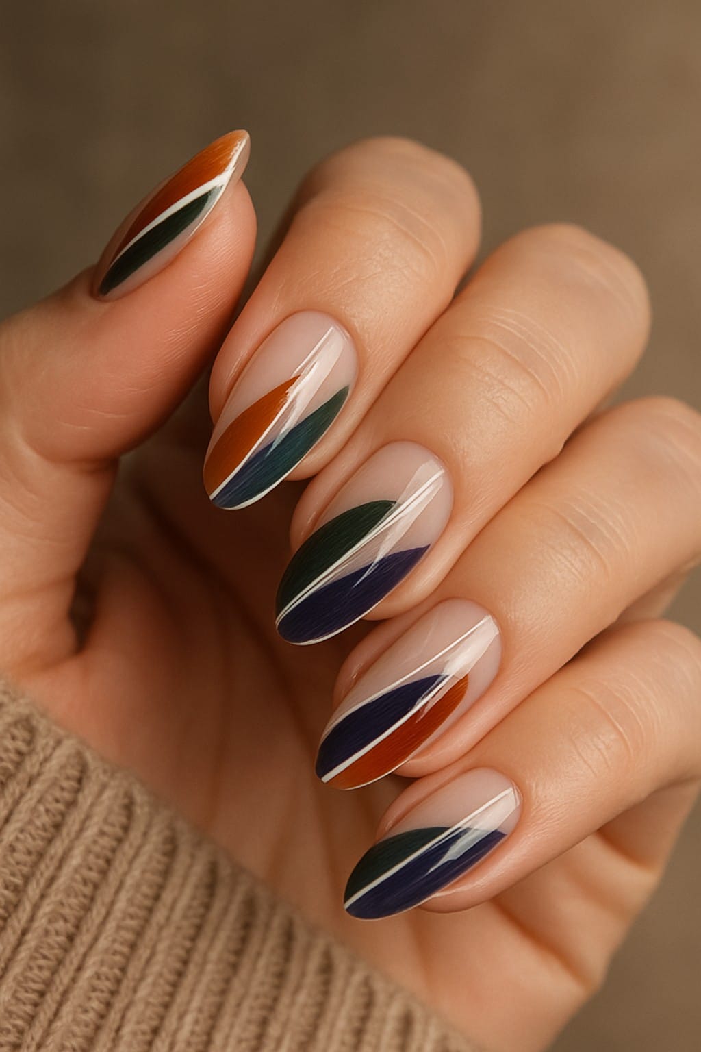 Bold autumn nail art featuring orange, green, blue, and white diagonal stripes
